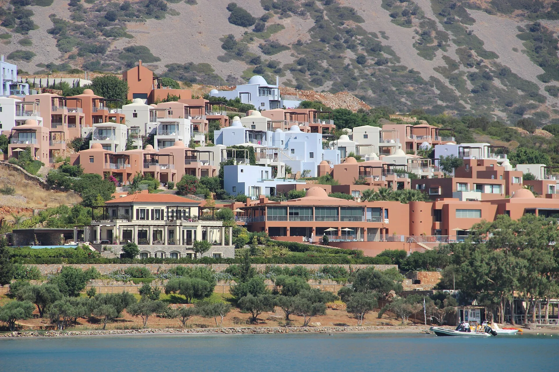 Witte bungalows met privepool van Blue Palace Elounda en uitzicht op Spinalonga eiland